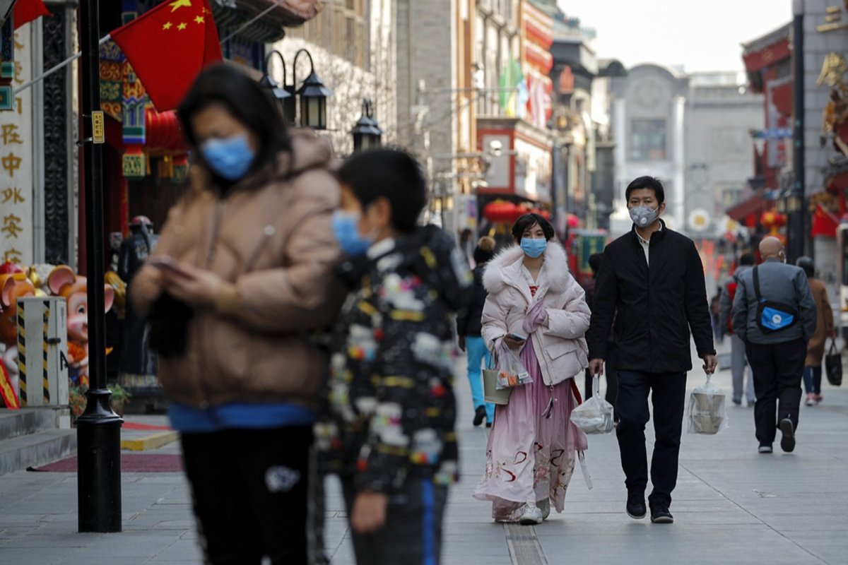 Građani sa zaštitnim maskama na licu šetaju ulicama Pekinga (Foto: Andy Wong/Associated Press)
